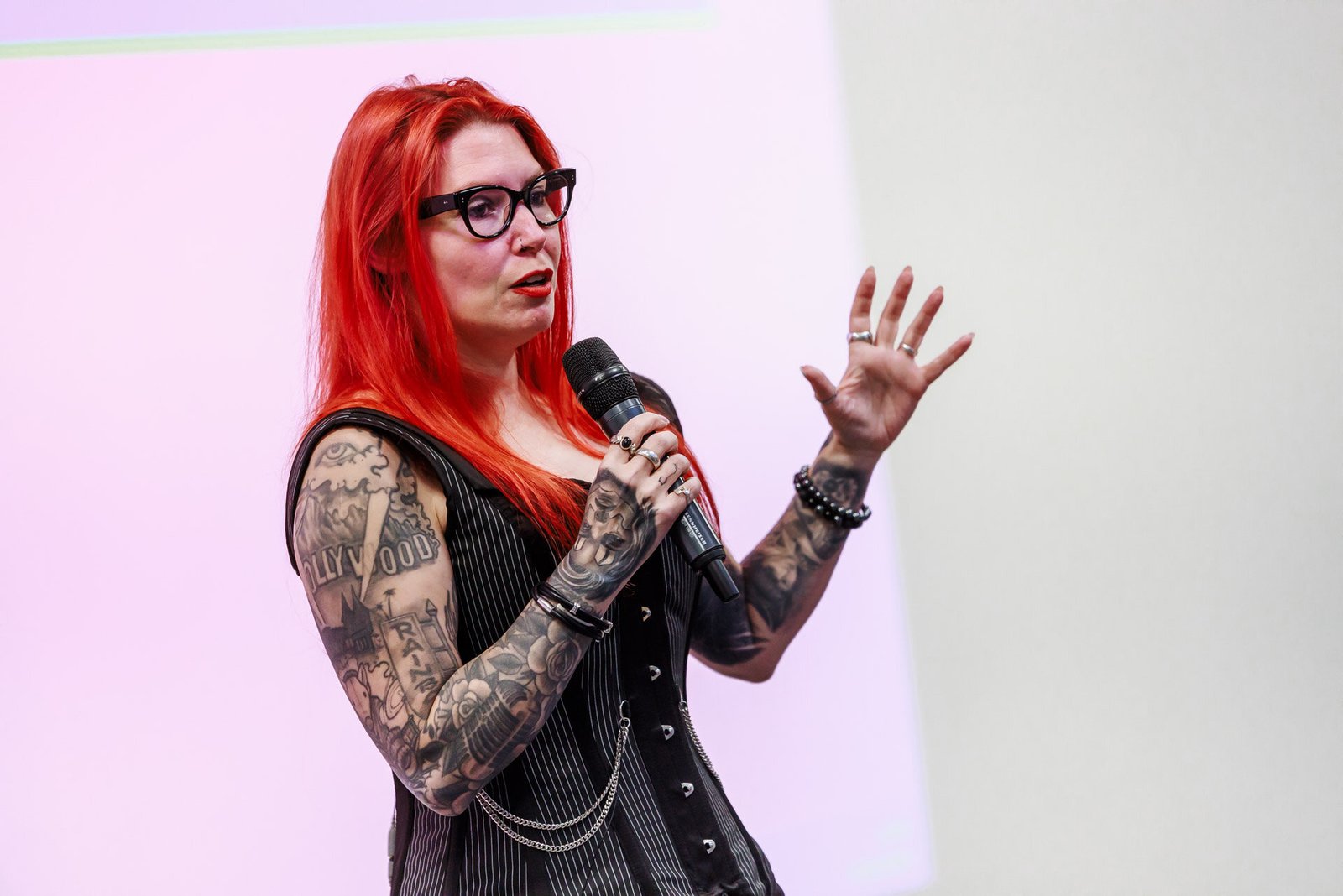 Ronia Fraser presenting live, mid-gesture with a microphone